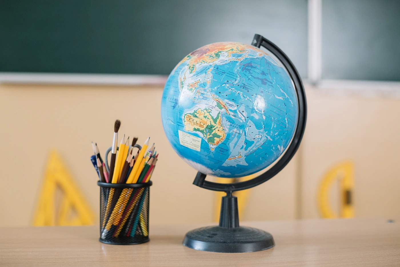 Globe, cahiers et fournitures scolaires posés sur un bureau